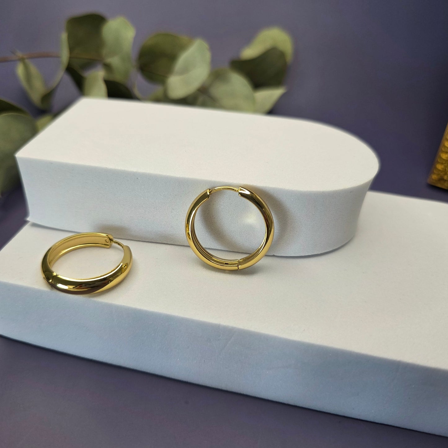 Line of Luxe hoops displayed on a white foam stellation. These 2.5cm 18K gold plated waterproof earrings made of 304 stainless steel feature a wide huggie design - My Silver Lining.