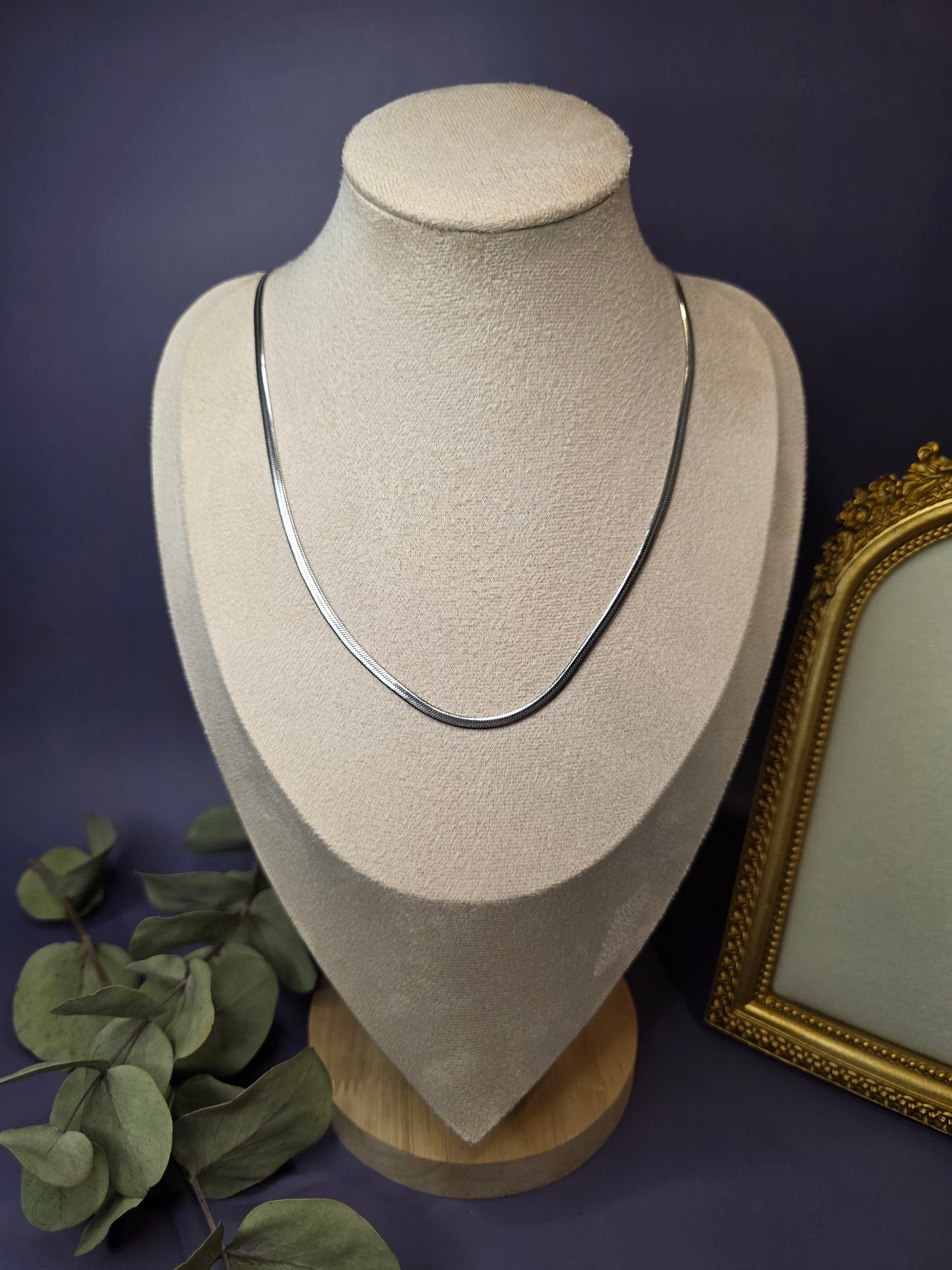 Liquid Silver Snake Chain necklace styled on a white jewelry bust. This stainless steel herringbone necklace showcases a fluid, liquid-like drape and high-shine silver finish - My Silver Lining.