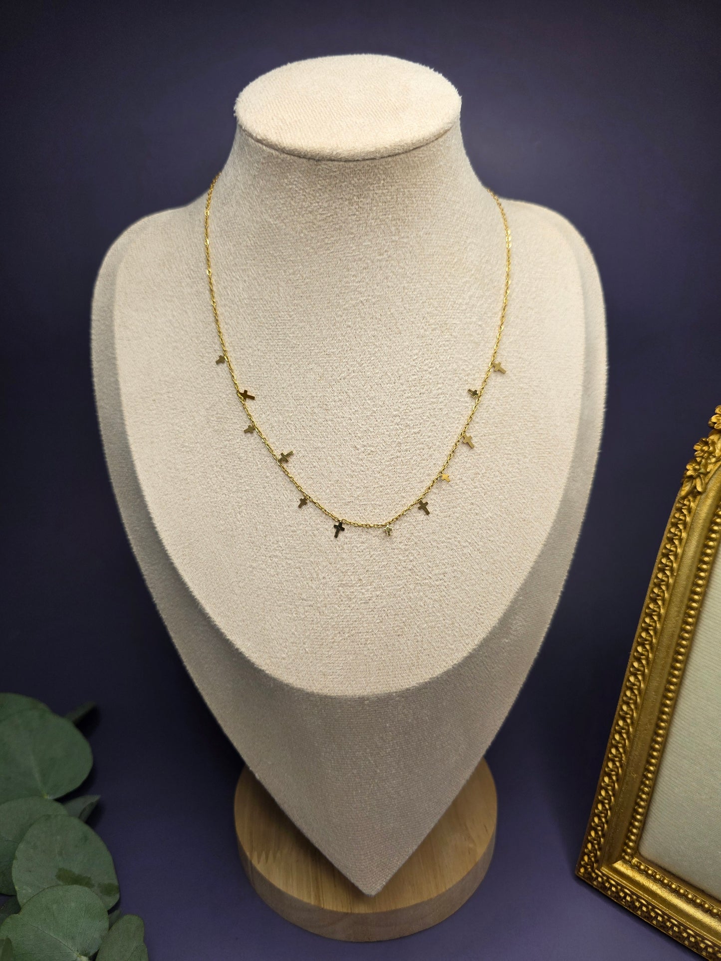 18k Gold plated station necklace with small cross charms showcased on a cream jewelry bust. Crafted from durable, tarnish-resistant 304 stainless steel, this piece is perfect for everyday elegance and individual style.