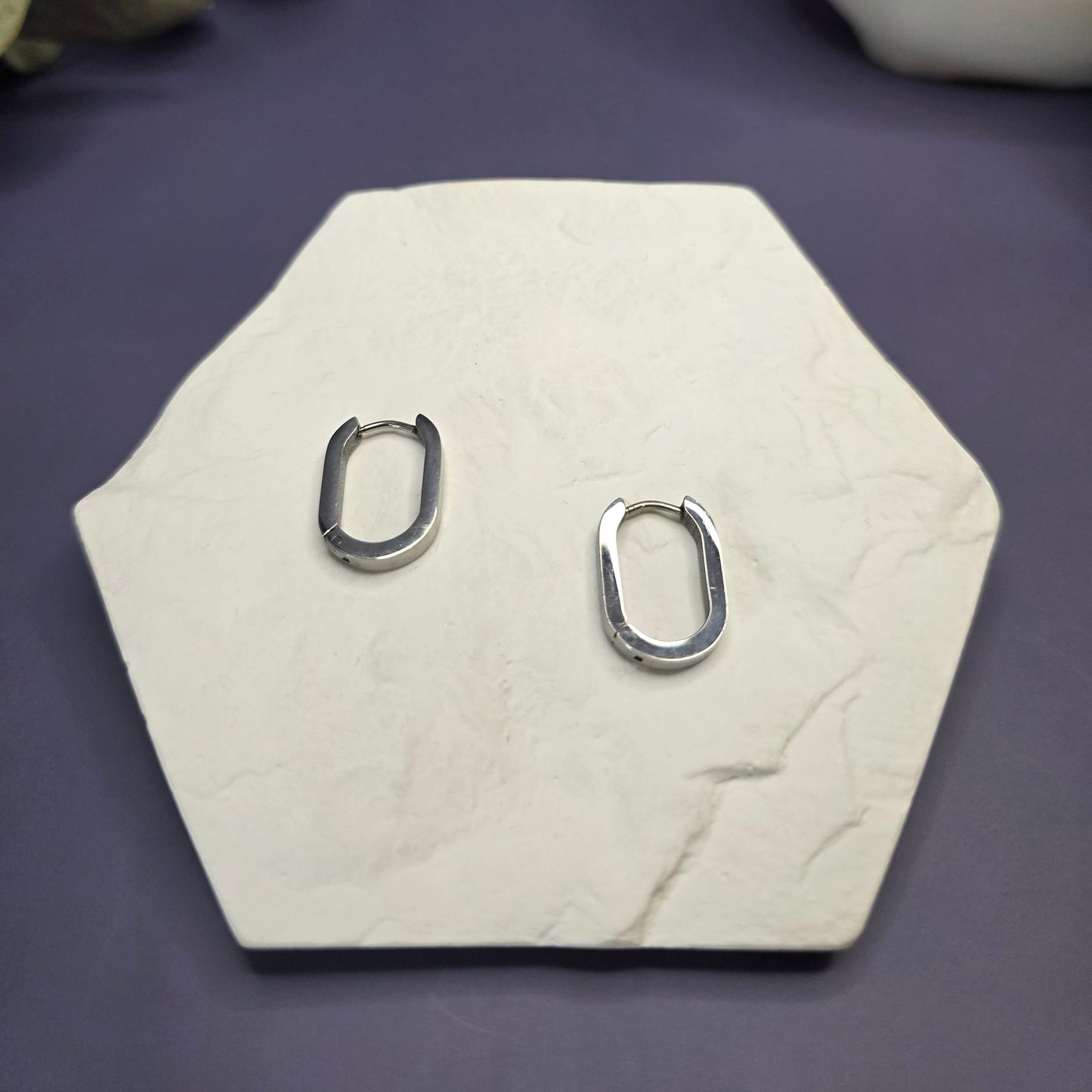 Silver Soft Square Hoops on a white hexagon display — My Silver Lining.