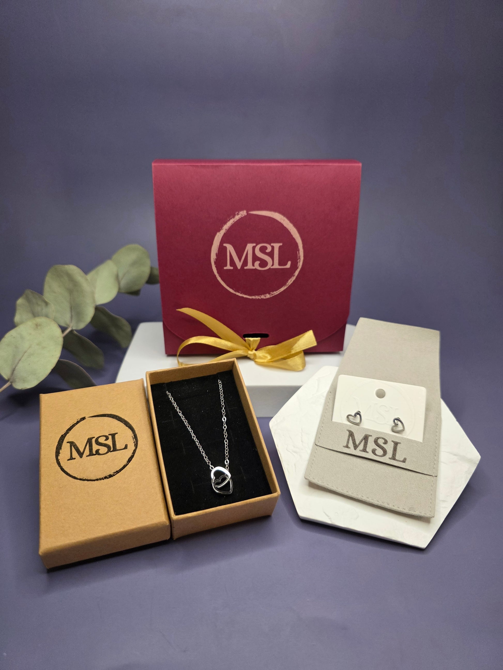 Valentine’s Day gift set featuring a silver dual interlocking heart necklace and dainty Cupido heart stud earrings by My Silver Lining. Beautiful packaging.