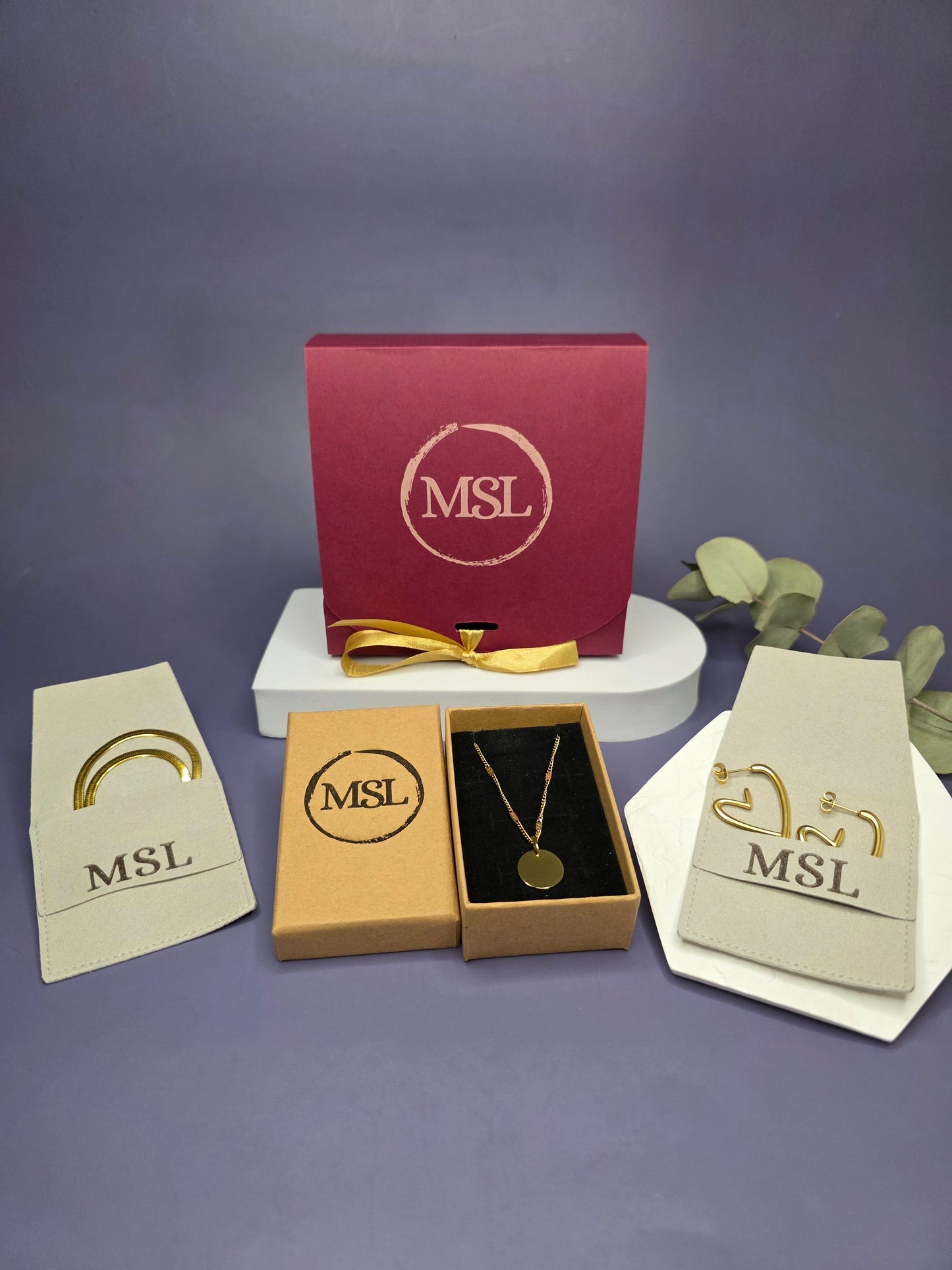 Luxury MSL Valentine’s packaging with 18k gold plated heart earrings and a 14k gold plated 316 stainless steel engravable pendant in a premium jewelry box.
