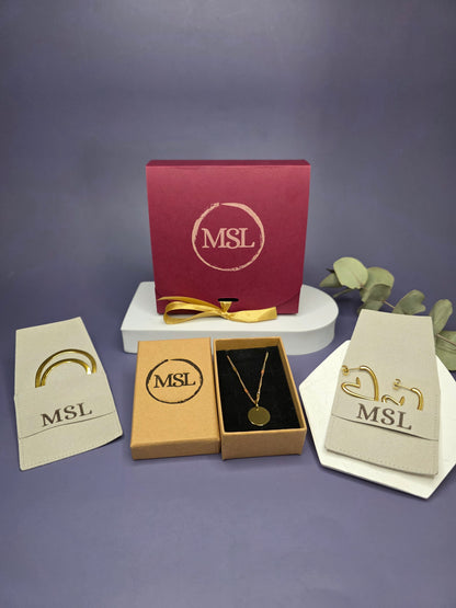 Luxury MSL Valentine’s packaging with 18k gold plated heart earrings and a 14k gold plated 316 stainless steel engravable pendant in a premium jewelry box.