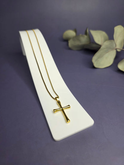 Angled view of the Anchor of Faith Cross Necklace in 18k gold plated stainless steel on a white display stand — My Silver Lining.