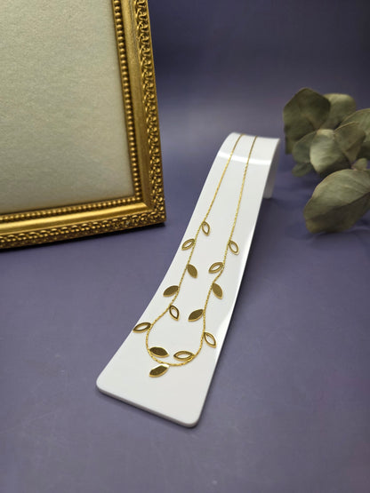 Botanical gold leaf necklace showcased on a jewelry display stand. Crafted from hypoallergenic stainless steel, this 18k gold plated necklace is designed for durable everyday elegance and effortless style - My Silver Lining.