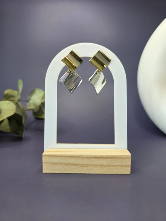 Duo-Tone Geometry drops featured on a white arch jewelry stand. These bold geometric mixed metal earrings provide a modern architectural silhouette and hypoallergenic finish - My Silver Lining.