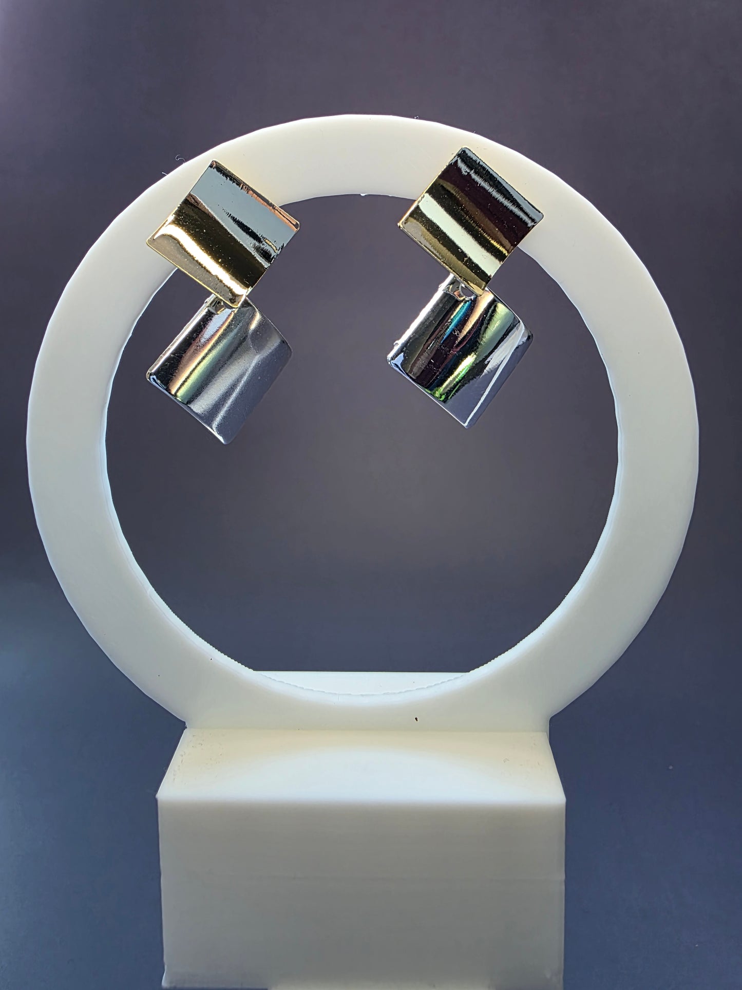 Duo-Tone Geometry drops featured on a white circular arch jewelry stand. These bold geometric mixed metal earrings provide a modern architectural silhouette and hypoallergenic finish - My Silver Lining.