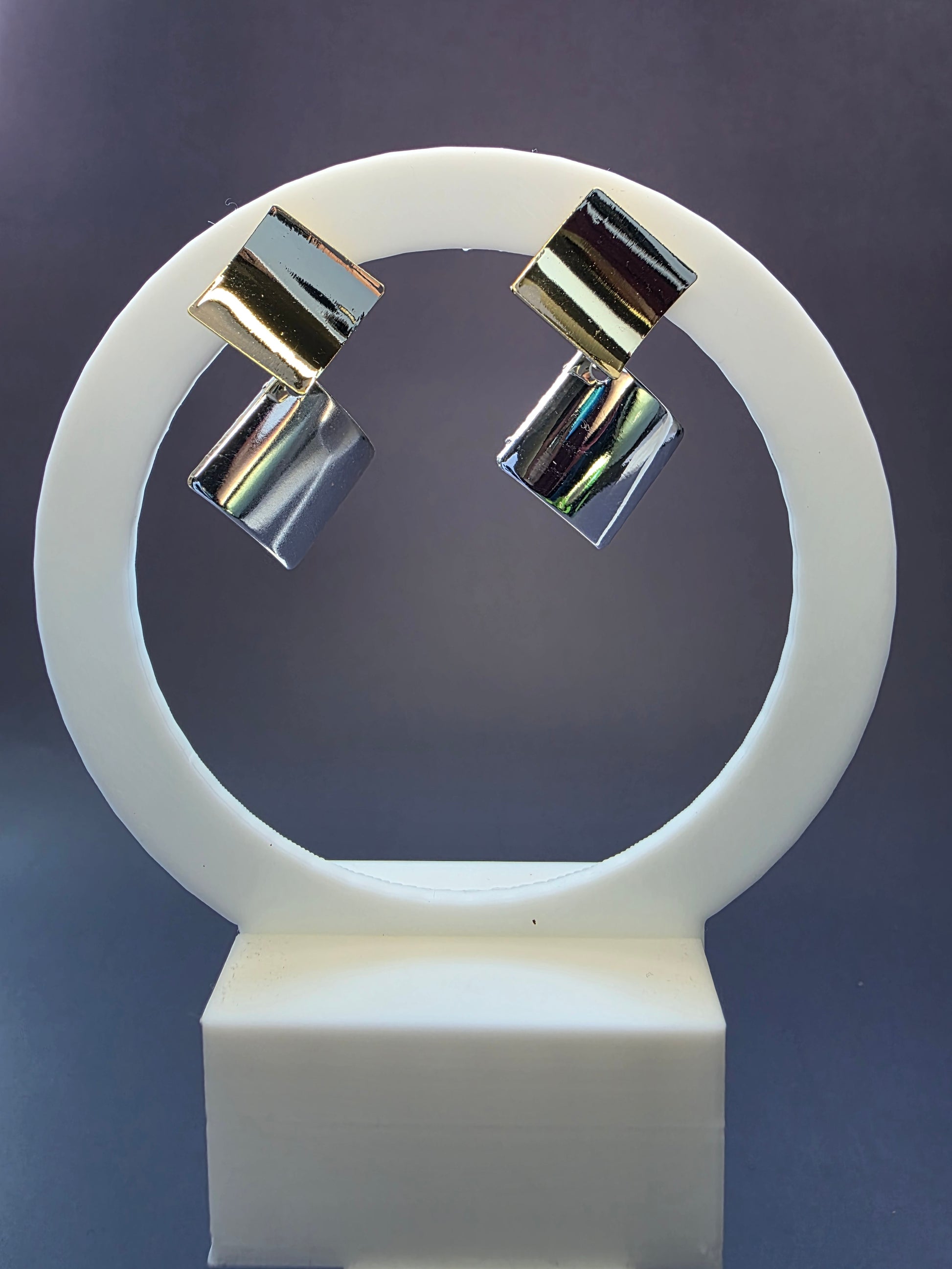 Duo-Tone Geometry drops featured on a white circular arch jewelry stand. These bold geometric mixed metal earrings provide a modern architectural silhouette and hypoallergenic finish - My Silver Lining.