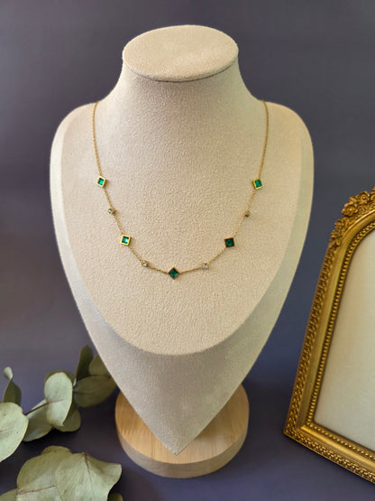 Emerald Glow Station necklace with vibrant green stones displayed on a jewelry bust. A tarnish-proof gold-plated station-style necklace designed for a sophisticated and radiant look - My Silver Lining.