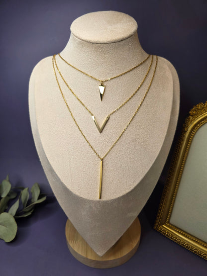 Golden Flying V layered necklace styled on a white jewelry bust. This 18K gold plated waterproof necklace features a triangle, chevron, and bar pendant - My Silver Lining.