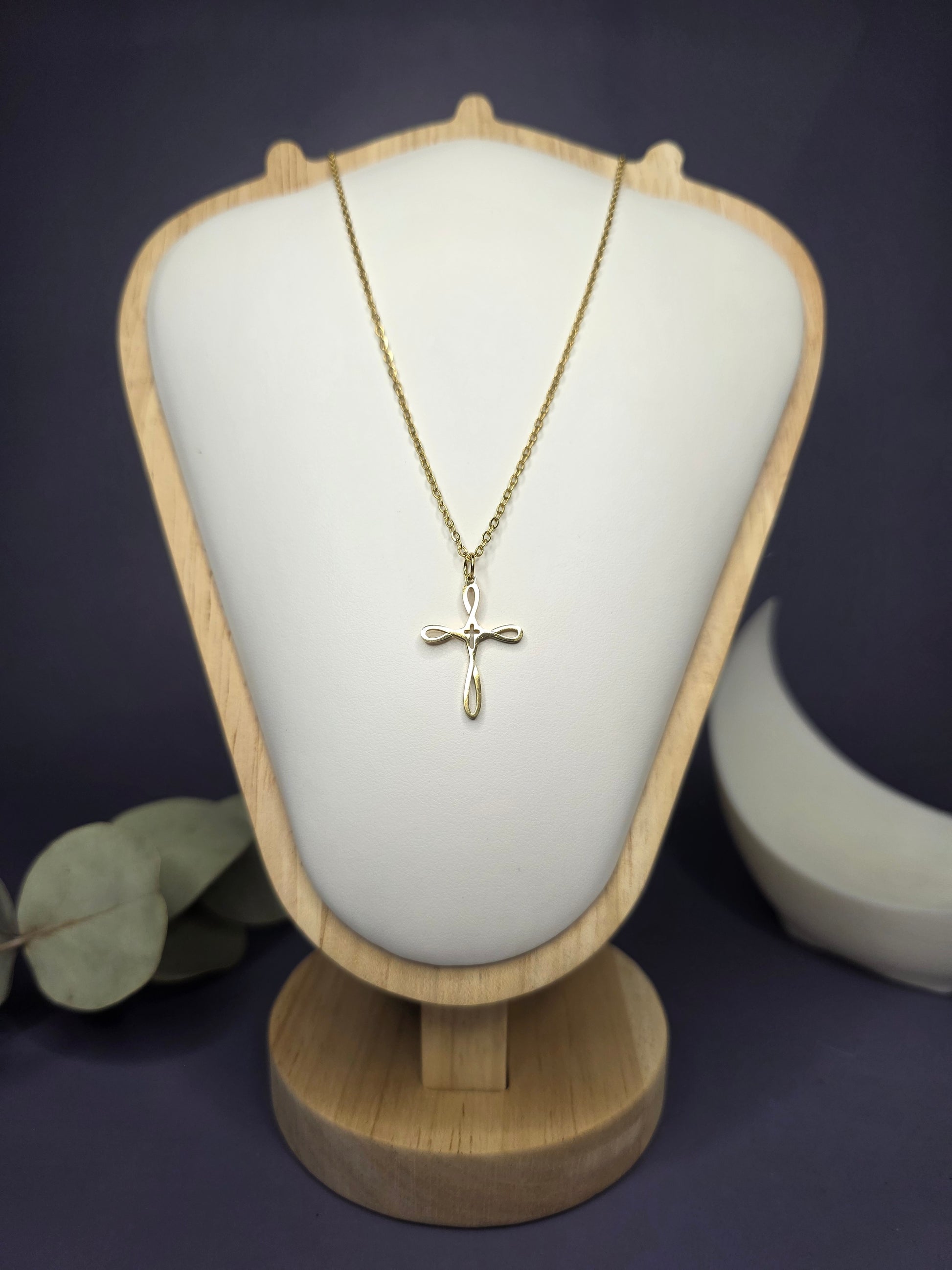 Front view of the Golden Infinity Cross pendant on a jewelry bust, showcasing the gold-toned finish and 42cm length — My Silver Lining.