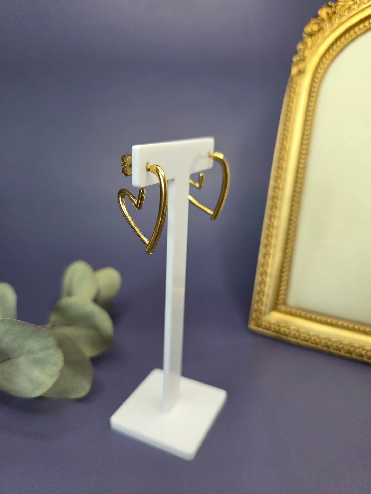 18k gold plated open heart earrings featured on a white T-stand display. These 3x3 cm waterproof 316 stainless steel heart hoops offer a radiant, minimalist silhouette for luxury everyday wear - My Silver Lining.