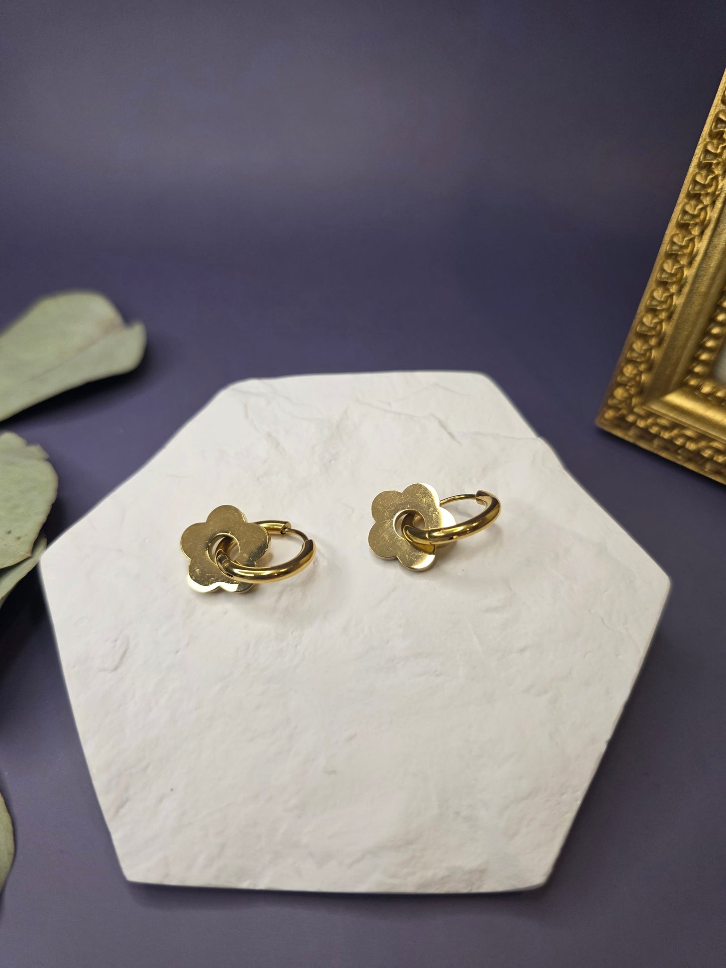 Detail shot of Golden Retro Bloom Hoops resting on a white hexagonal stone. Tarnish-resistant 18K gold-plated floral earrings with 316 stainless steel needles designed for durable, everyday elegance - My Silver Lining.
