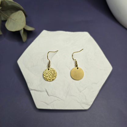 Top view of the Honey Gold Hammered Drops on a white stone, showing the textured 316 stainless steel finish — My Silver Lining.