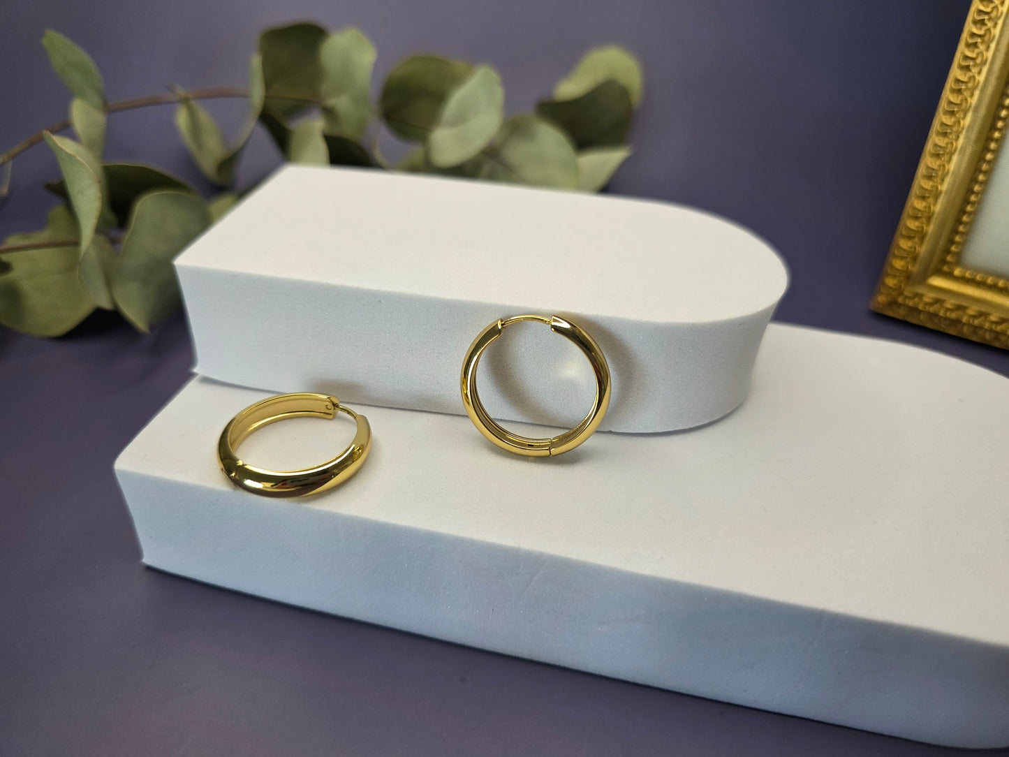 Line of Luxe hoops displayed on a white foam stellation. These 2.5cm 18K gold plated waterproof earrings made of 304 stainless steel feature a wide huggie design - My Silver Lining.