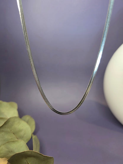 Liquid Silver Snake Chain necklace shown floating to highlight the seamless flat herringbone links. Tarnish-resistant stainless steel with a 40cm adjustable length - My Silver Lining.