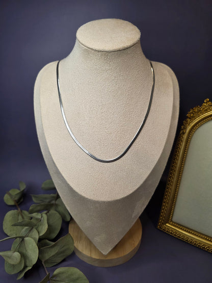 Liquid Silver Snake Chain necklace styled on a white jewelry bust. This stainless steel herringbone necklace showcases a fluid, liquid-like drape and high-shine silver finish - My Silver Lining.