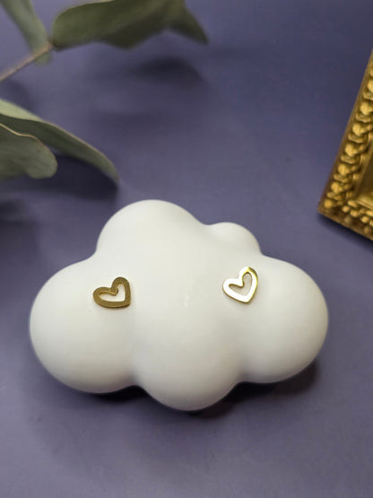 Close-up of the Little Cupido gold heart earrings on a white cloud-shaped display. Petite, tarnish-proof KC gold-plated heart studs for sensitive skin and multiple piercings - My Silver Lining.