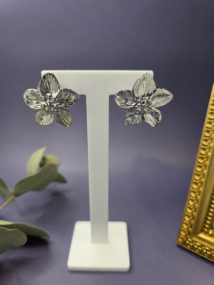 Front view of Moonlight Blossom silver flower stud earrings on a white display stand. These tarnish-resistant stainless steel earrings feature a sunburst texture, perfect for sensitive skin - My Silver Lining.