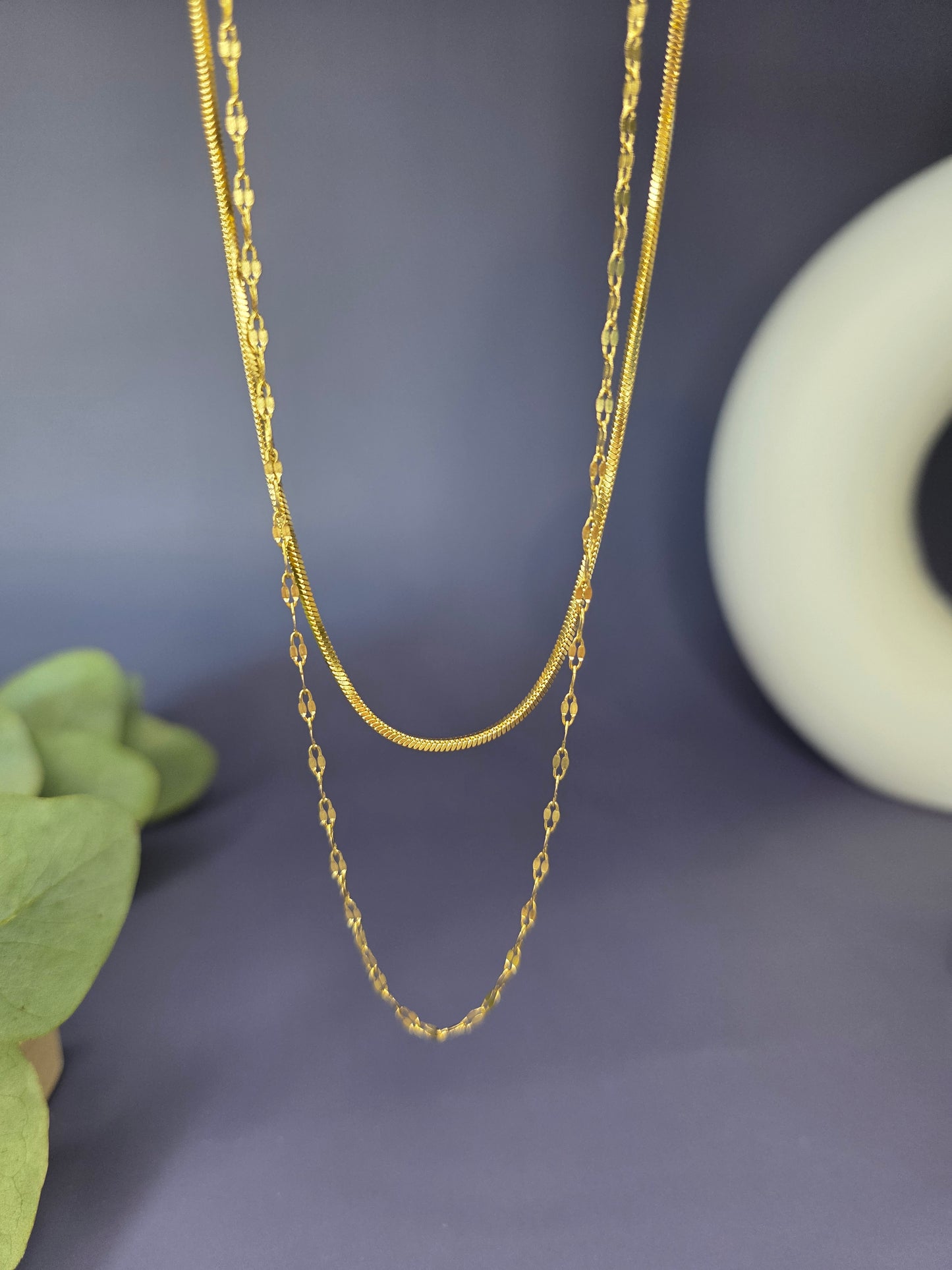 The Golden Line Harmony necklace, a double-piece, double-layered silver-toned necklace featuring a smooth flat chain and a fine beaded satellite chain