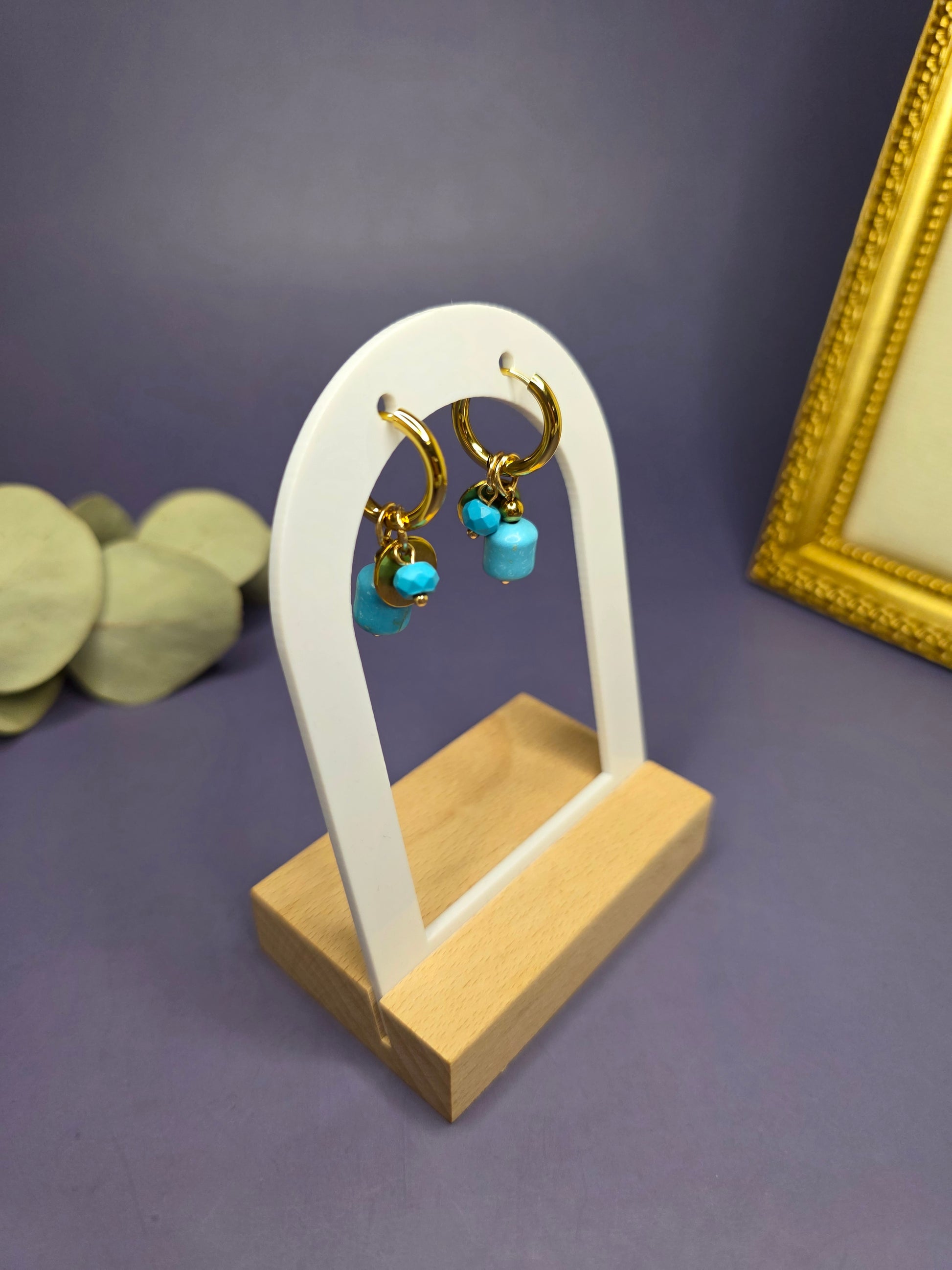 Nomad Turquoise Hoops displayed on a white architectural arch. These 18k gold plated stainless steel earrings feature removable natural-cut turquoise stones — My Silver Lining.