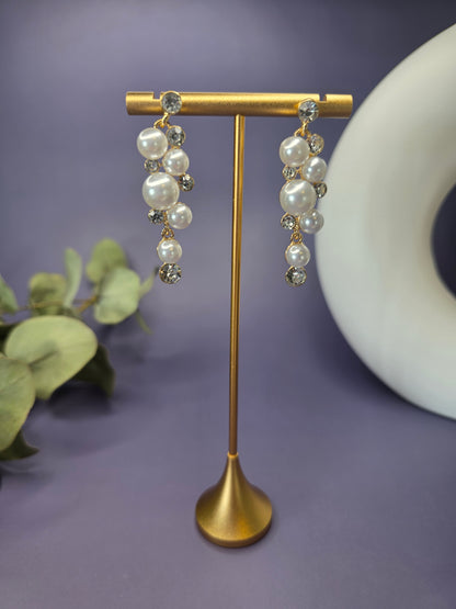 Pearl Cluster Drops suspended from a golden T-bar jewelry stand. These 5cm long 14K gold plated cluster earrings showcase sparkling rhinestones and elegant pearls for cocktail events - My Silver Lining.