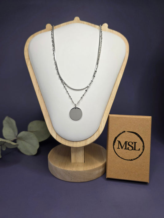 Personalized Silver Lustre Duo necklace set styled on white shield. This stainless steel set features an engravable silver disc pendant with a layered snake and satellite chain - My Silver Lining.