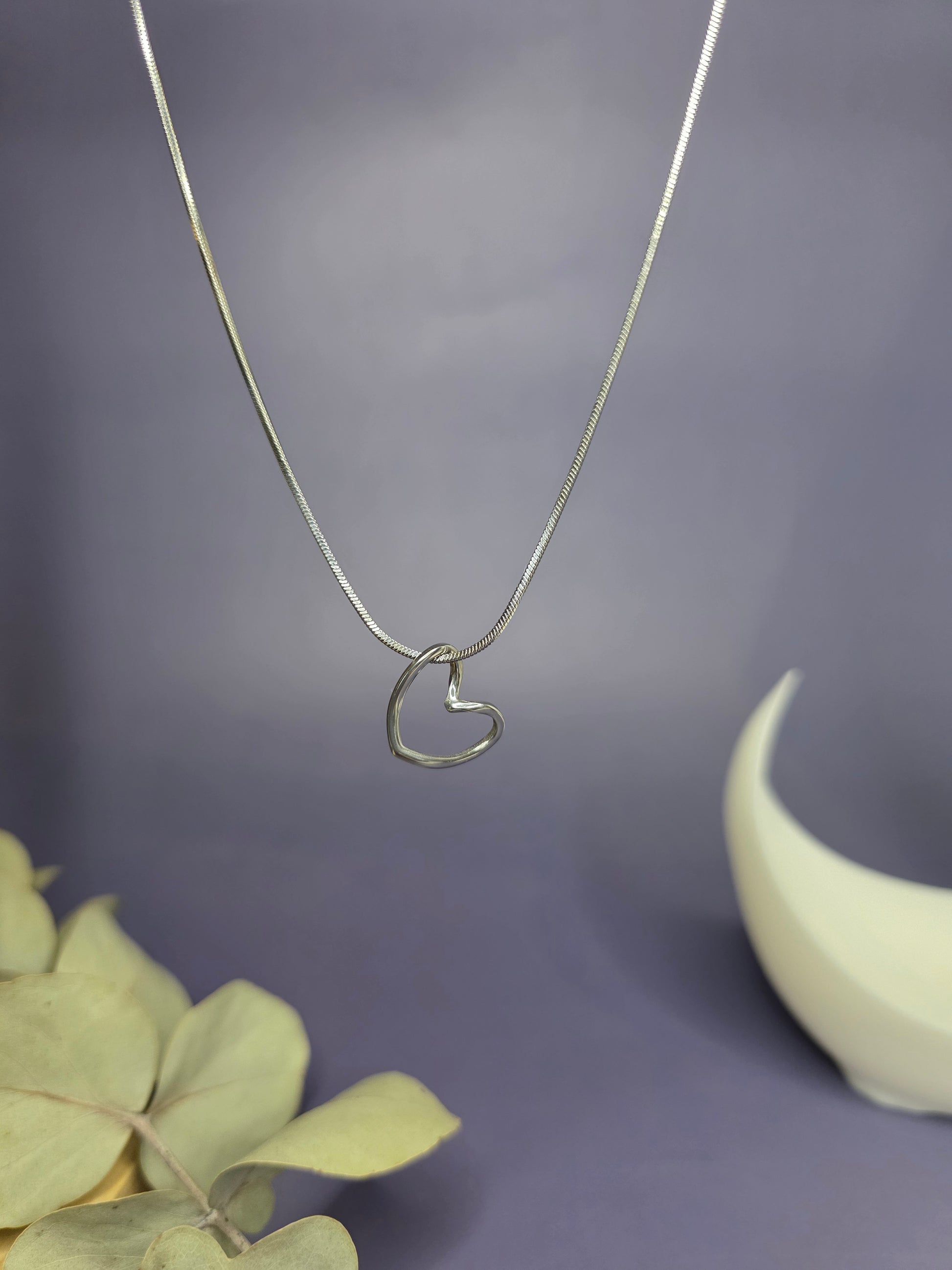 Close-up of the Pure Heart Silver Pendant Necklace in 316 stainless steel, featuring a minimalist open heart design on a silver snake chain — My Silver Lining.