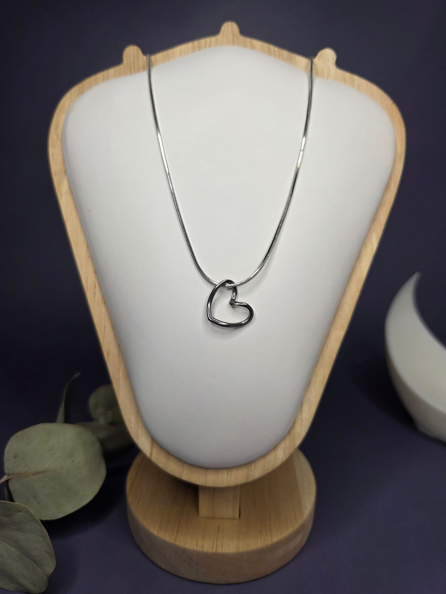 Front view of the Pure Heart Silver Pendant Necklace on a white and wood display stand, highlighting the high-quality 316 stainless steel construction — My Silver Lining.