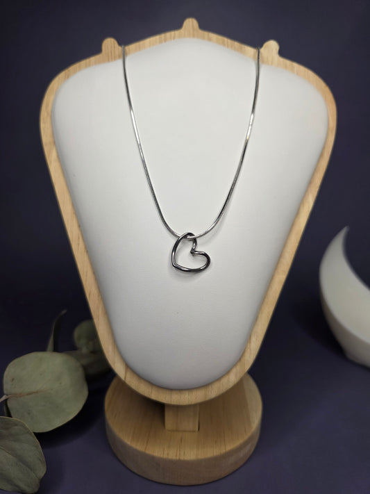 Front view of the Pure Heart Silver Pendant Necklace on a white and wood display stand, highlighting the high-quality 316 stainless steel construction — My Silver Lining.
