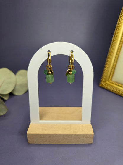 Rustic Olive Huggies displayed on a white architectural arch. 18k gold plated stainless steel earrings with natural green stone charms — My Silver Lining.