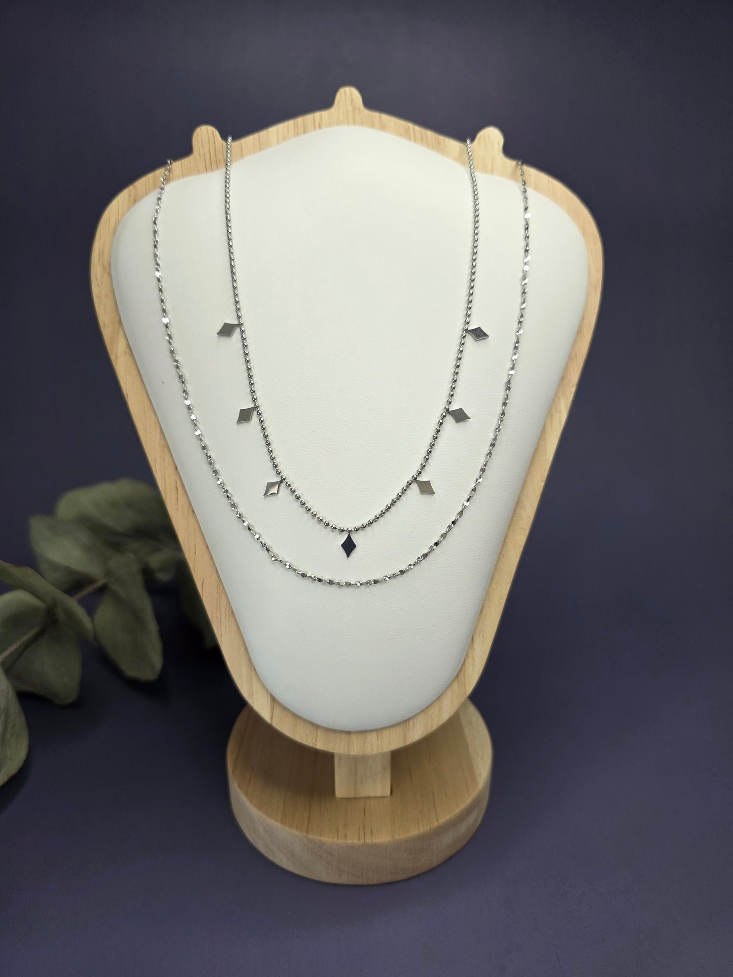 Silver Diamond-Drop Duo layered necklace styled on a white jewelry white shield. This 316 stainless steel silver necklace features satellite beads and diamond charms - My Silver Lining.