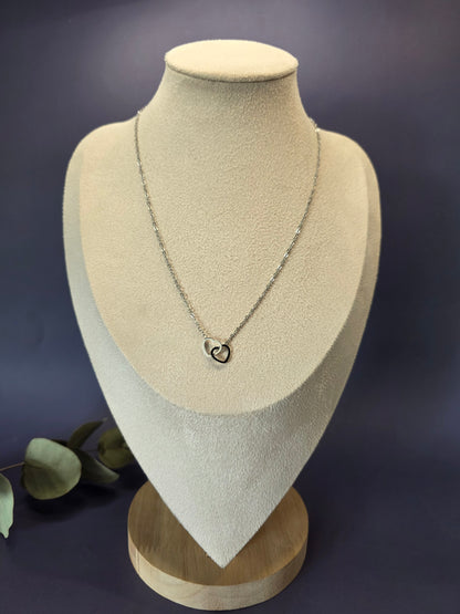 Silver Dual Hearts necklace displayed on a tan jewelry bust. This interlocking heart pendant in high-quality 316 stainless steel offers a waterproof, tarnish-resistant finish for a clean and modern look - My Silver Lining.