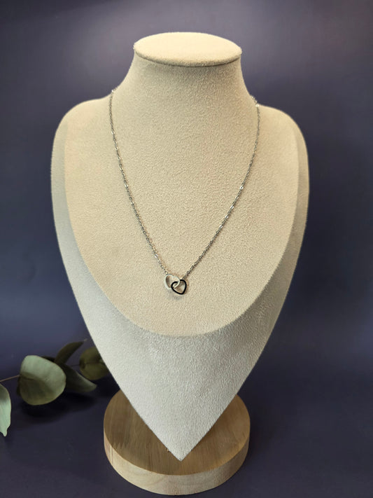 Silver Dual Hearts necklace displayed on a tan jewelry bust. This interlocking heart pendant in high-quality 316 stainless steel offers a waterproof, tarnish-resistant finish for a clean and modern look - My Silver Lining.