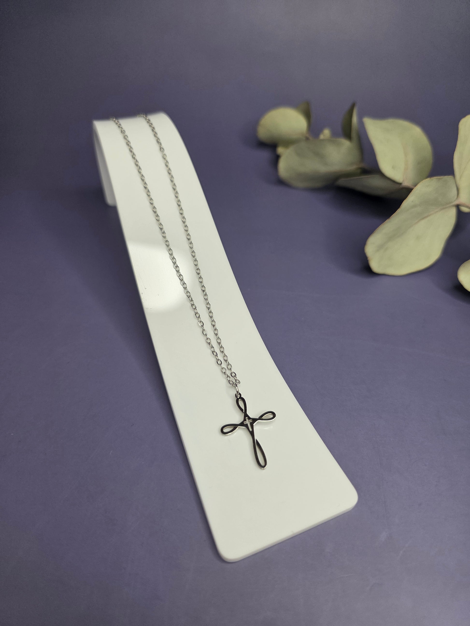 Angled view of the Silver Infinity Cross Necklace on a white display stand — My Silver Lining.