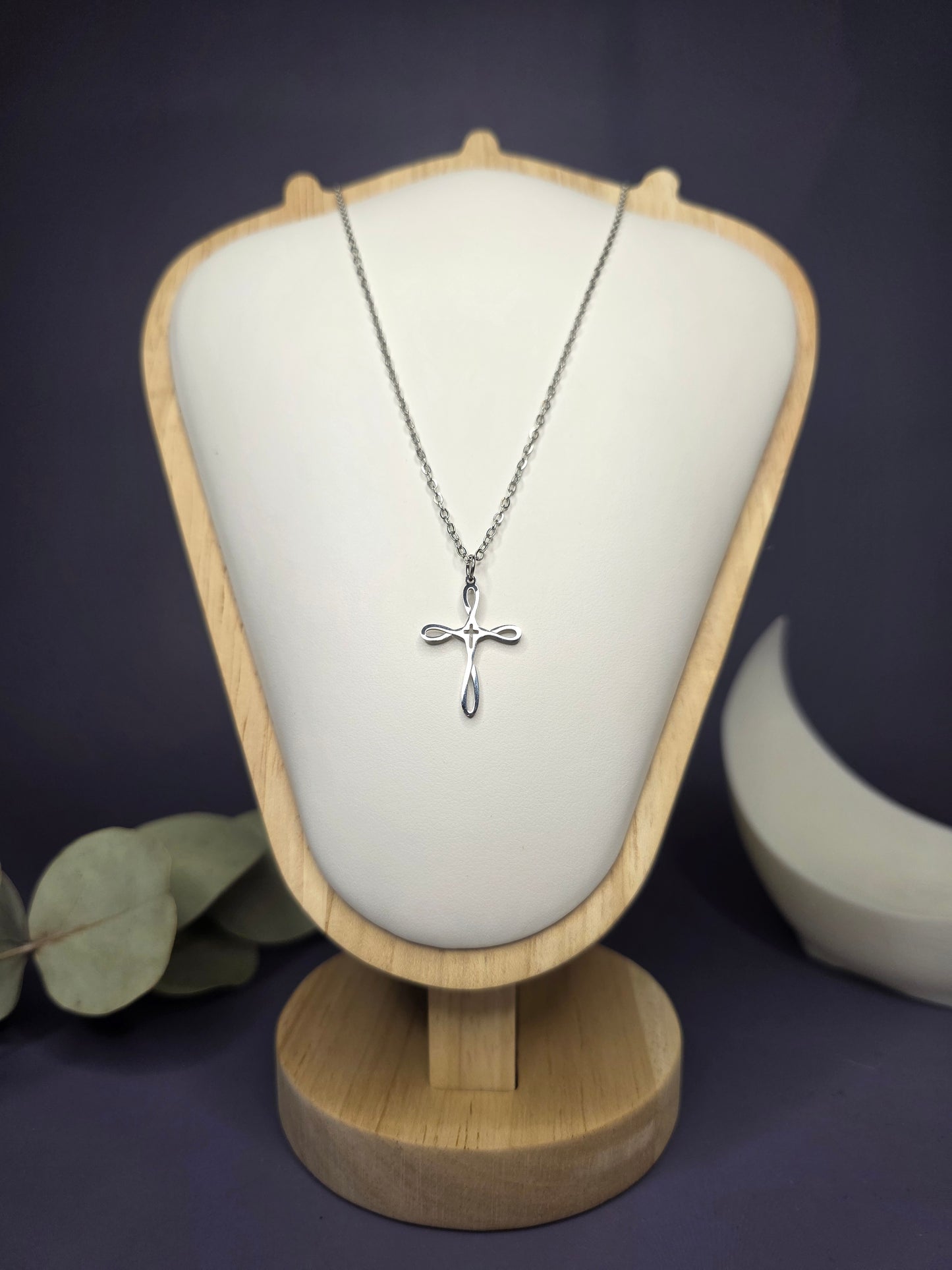 Front view of the Silver Infinity Cross pendant on a jewelry bust, showcasing the polished stainless steel and 42cm length — My Silver Lining.