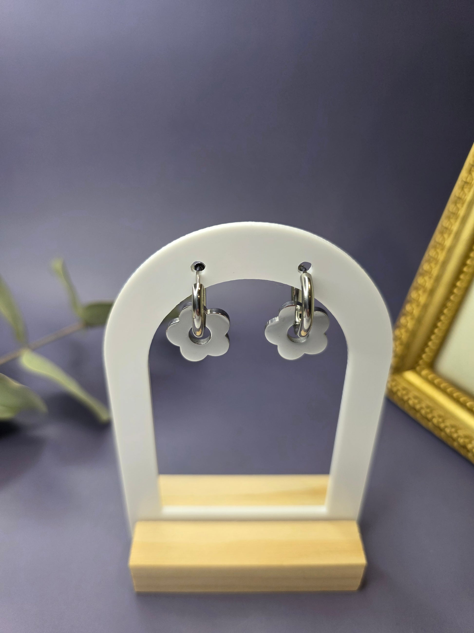 Silver Retro Bloom hoops featured on a white arch jewelry stand. These tarnish-resistant stainless steel floral hoops provide a playful vintage-inspired silhouette - My Silver Lining.