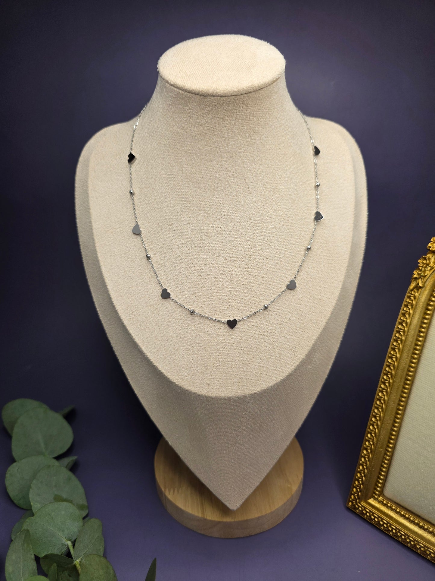 Silver rhythm heart necklace displayed on a cream jewelry bust. This waterproof stainless steel necklace features 0.6cm heart charms and a tarnish-resistant finish for a sophisticated look - My Silver Lining.