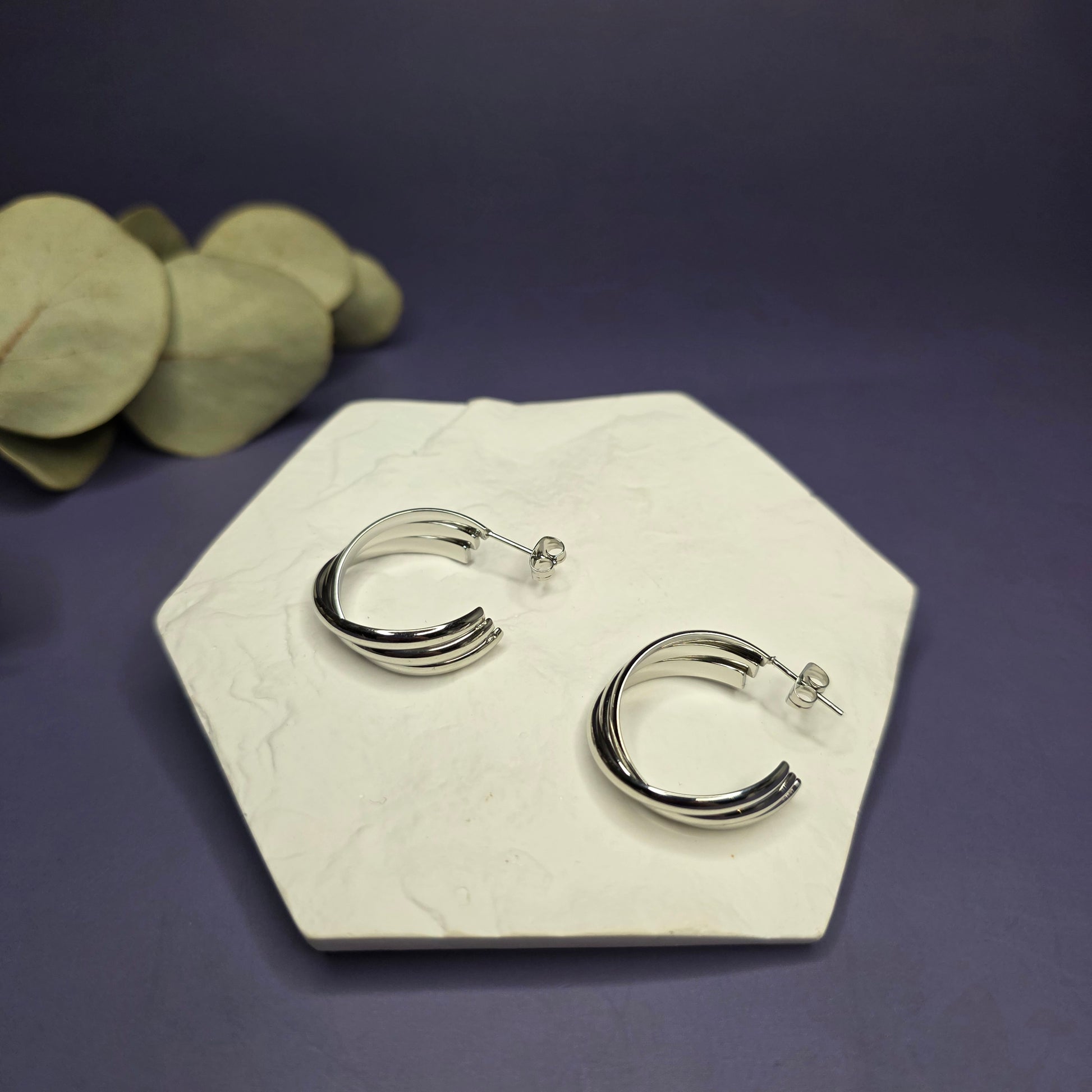 Perfect shot of Silver Tide Hoops, displaying the depth and unique curvature of the layered bands on a white hexagon — My Silver Lining.