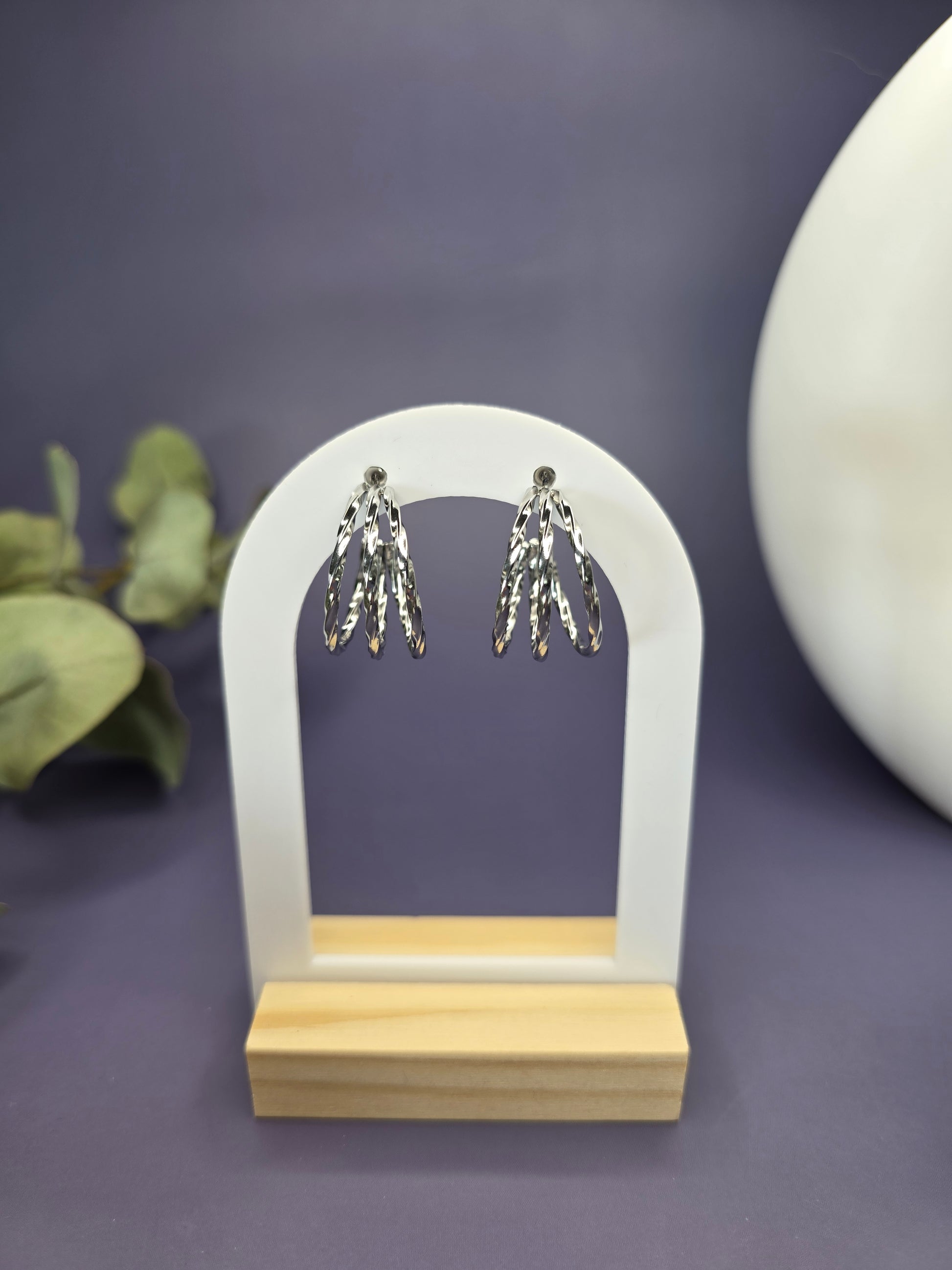 Silver Twist hoops featured on a white arch jewelry stand. These tarnish-resistant 304 stainless steel hoops provide a bold textured silhouette and a high-polish silver finish - My Silver Lining