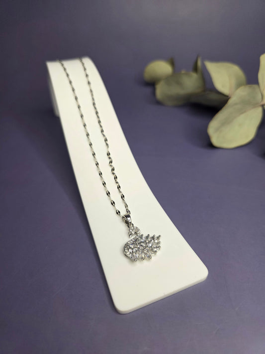 Angled view of the Silver White Swan Lake Necklace in polished stainless steel on a white display stand — My Silver Lining.