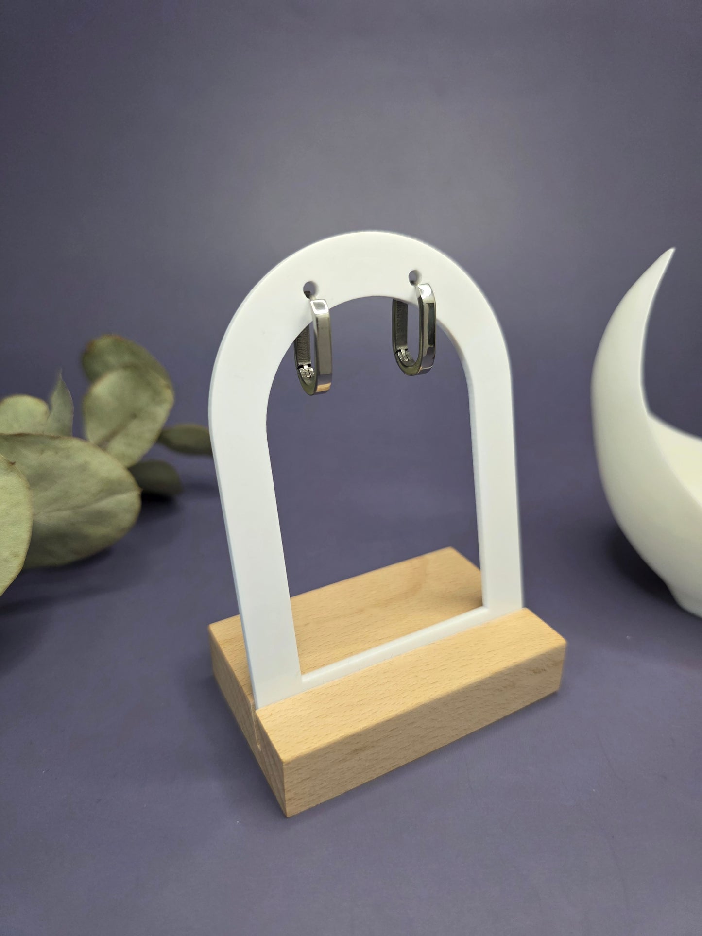 Soft Square silver hoops displayed on a white architectural arch. These 316 stainless steel square-round earrings are waterproof, tarnish-resistant, and hypoallergenic. Perfect sleepers — My Silver Lining.