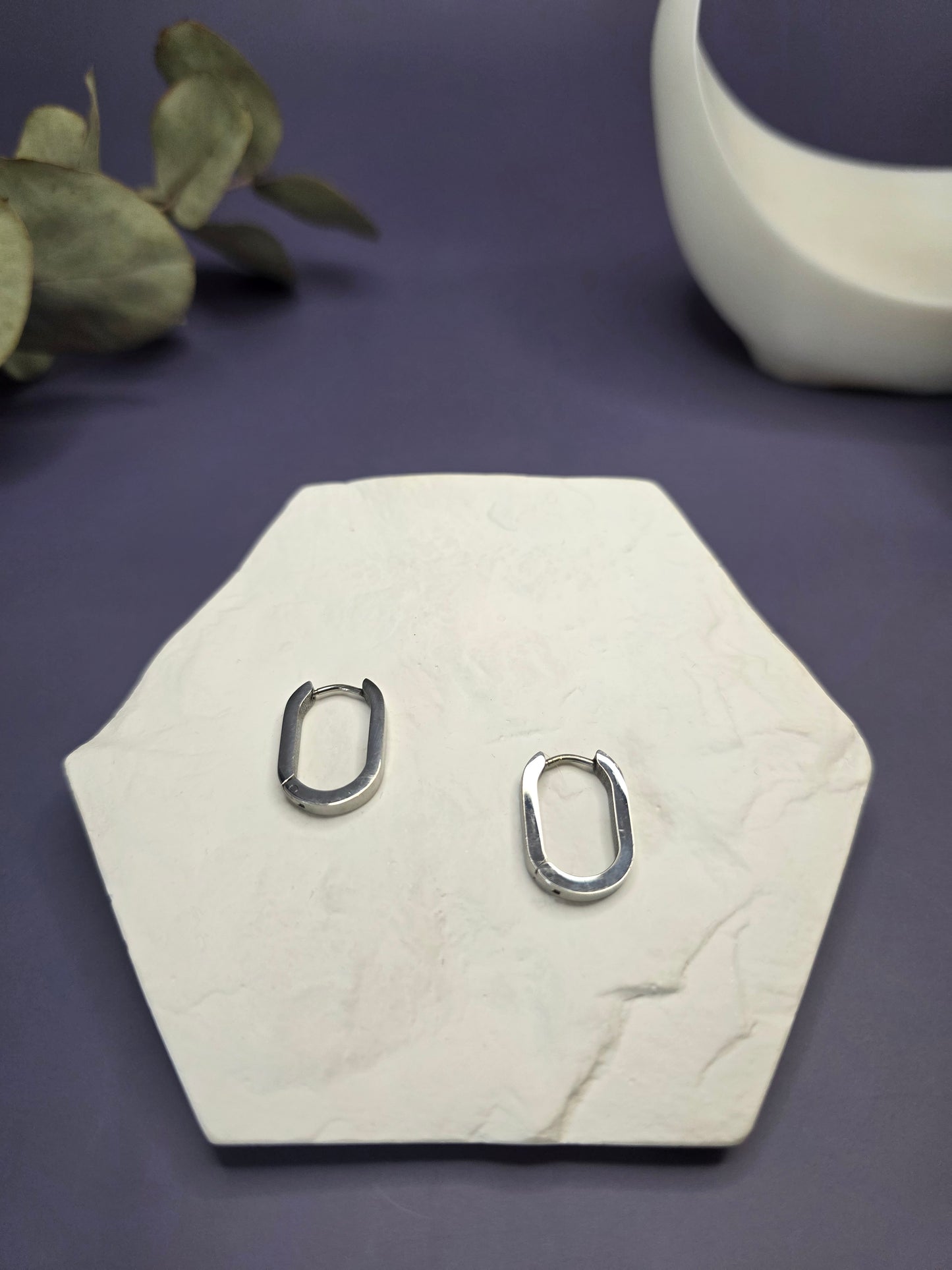 Soft Square silver hoops displayed on a white textured hexagon stone. These 316 stainless steel earrings are waterproof, tarnish-resistant, and hypoallergenic for everyday wear. Perfect sleepers — My Silver Lining.