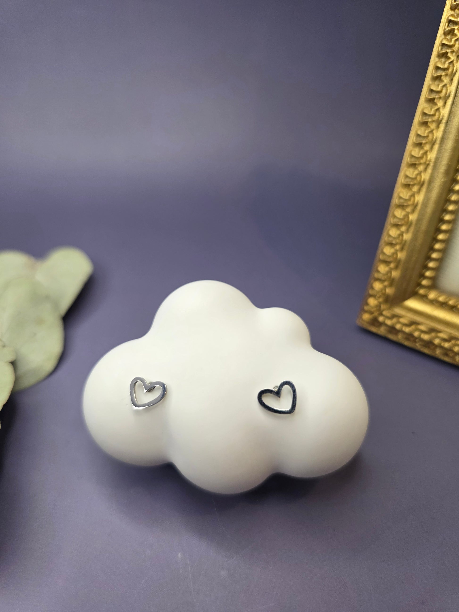 A pair of tiny, silver-toned 316 stainless steel heart-shaped stud earrings, displayed on a simple background.