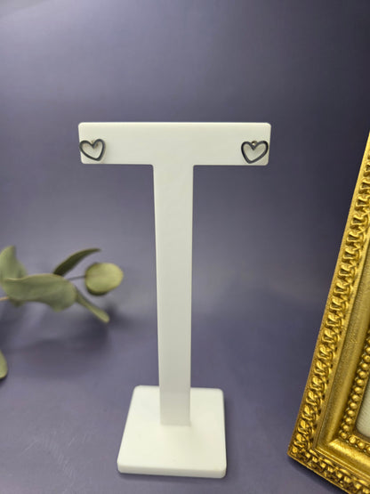 A pair of tiny, silver-toned 316 stainless steel heart-shaped stud earrings, displayed on a simple background