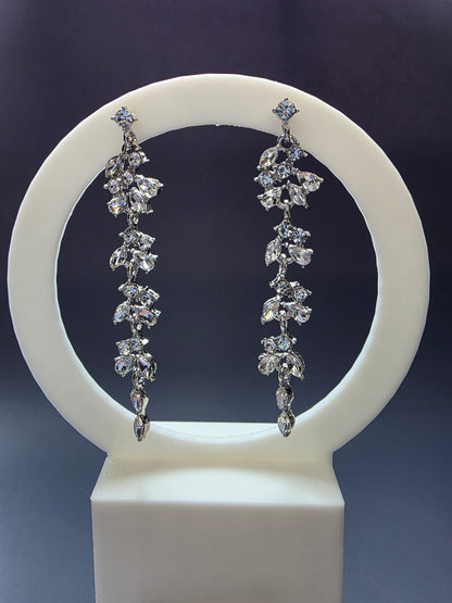 Starlight Vine Drops featured on a white arch jewelry stand. These 8cm long clear zircon chandelier earrings provide a dramatic silhouette and hypoallergenic S925 silver finish - My Silver Lining.
