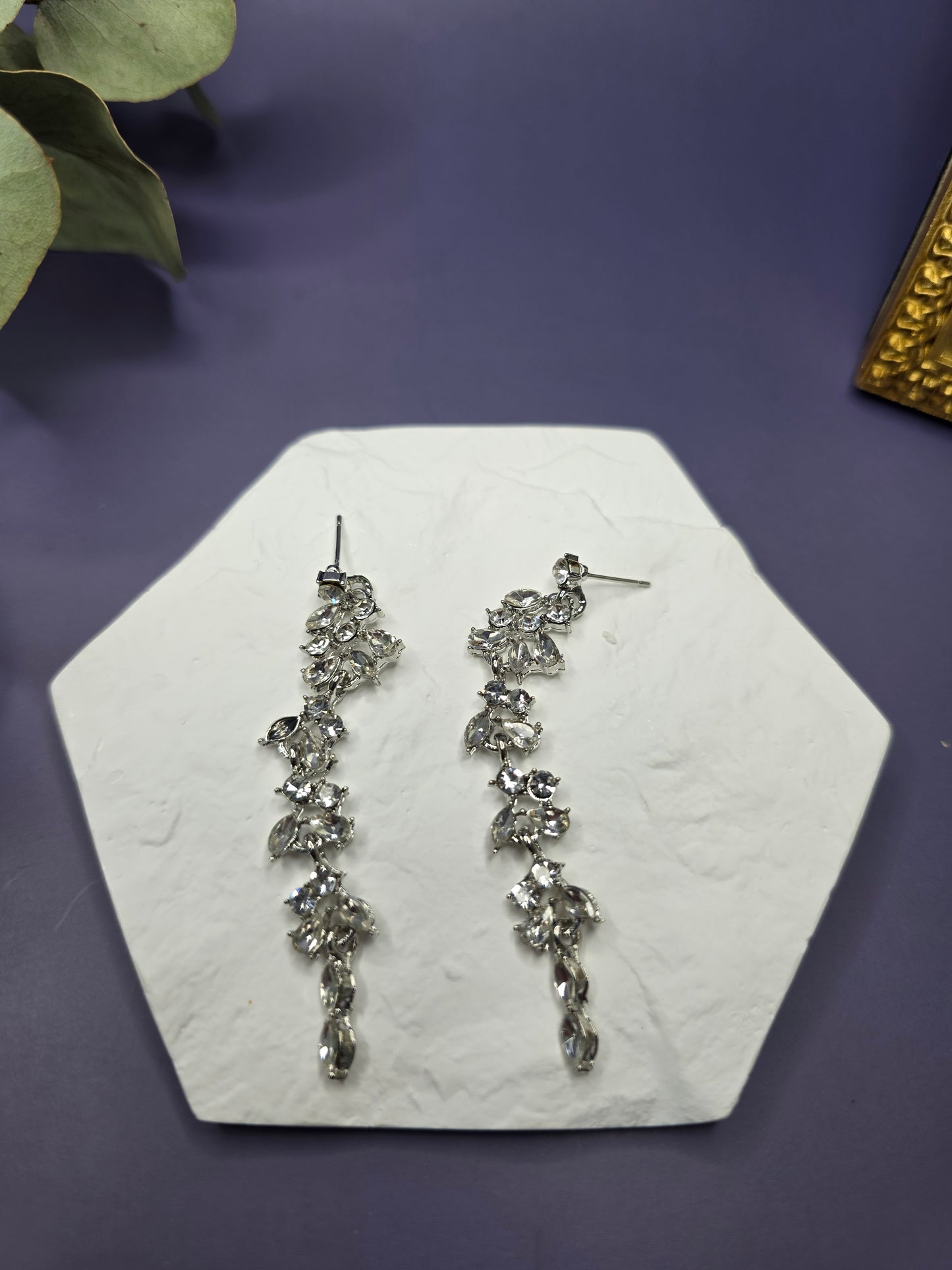 Starlight Vine Drops displayed on a white textured hexagon stone. These 8cm synthetic zircon statement earrings feature S925 sterling silver needles and a cascading vine design - My Silver Lining.