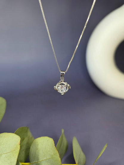 Elegant sterling silver necklace with a brilliant round cubic zirconia stone set in a polished silver swirl or halo pendant design.