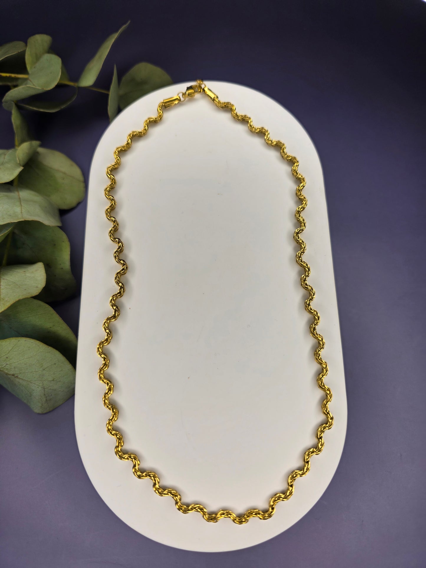Model view of the gold-plated Dorian Chain necklace, showing how the wavy-link choker rests gracefully on a beige fabric bust. The chain is 41 cm long with a 5 cm extender.