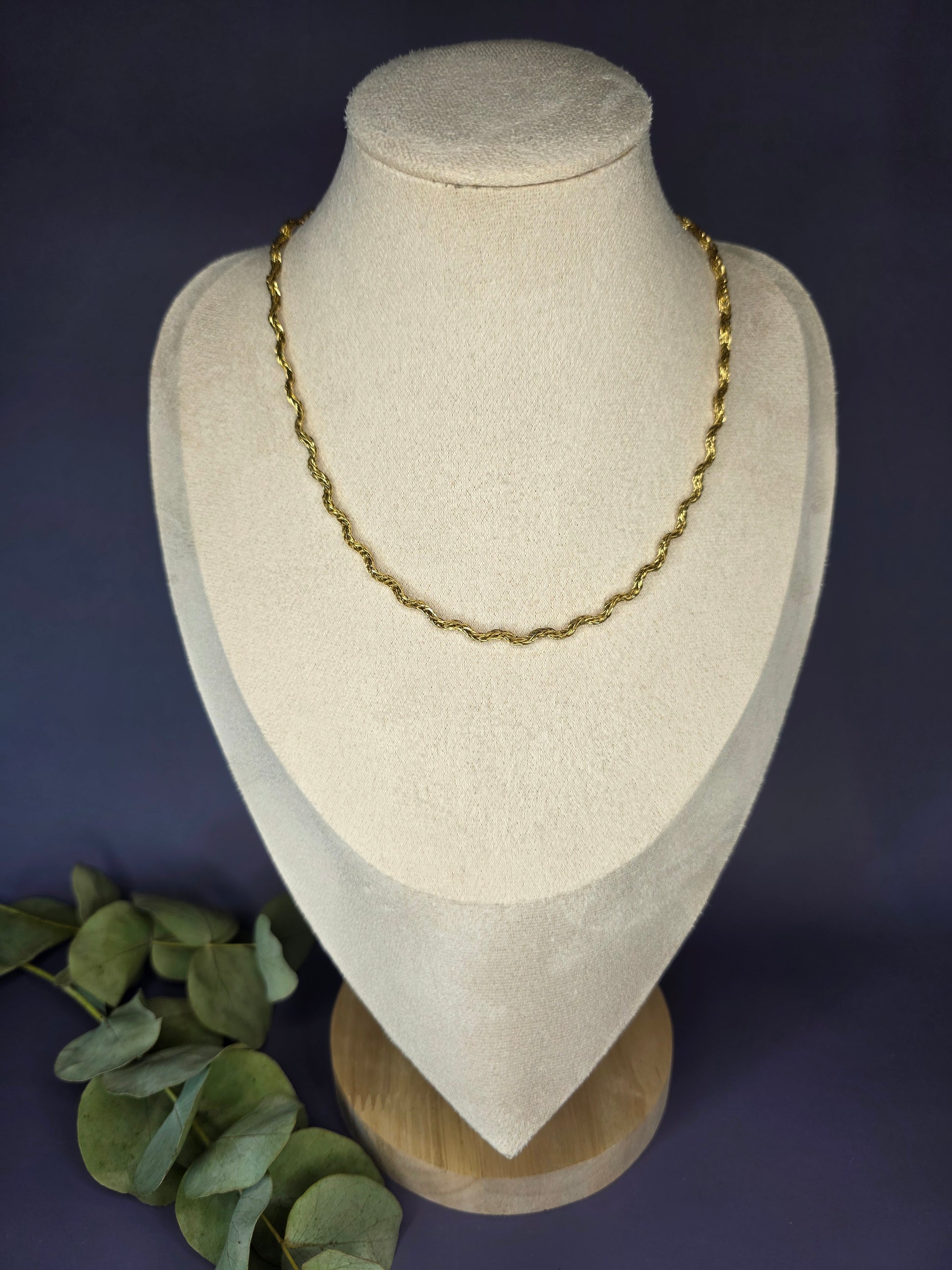 Model view of the gold-plated Dorian Chain necklace, showing how the wavy-link choker rests gracefully on a beige fabric bust. The chain is 41 cm long with a 5 cm extender.